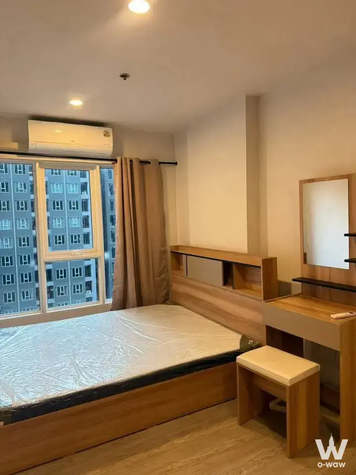 1-bed condo for rent in Regent Home Bangna featuring a modern bedroom with light wood furniture and large window
