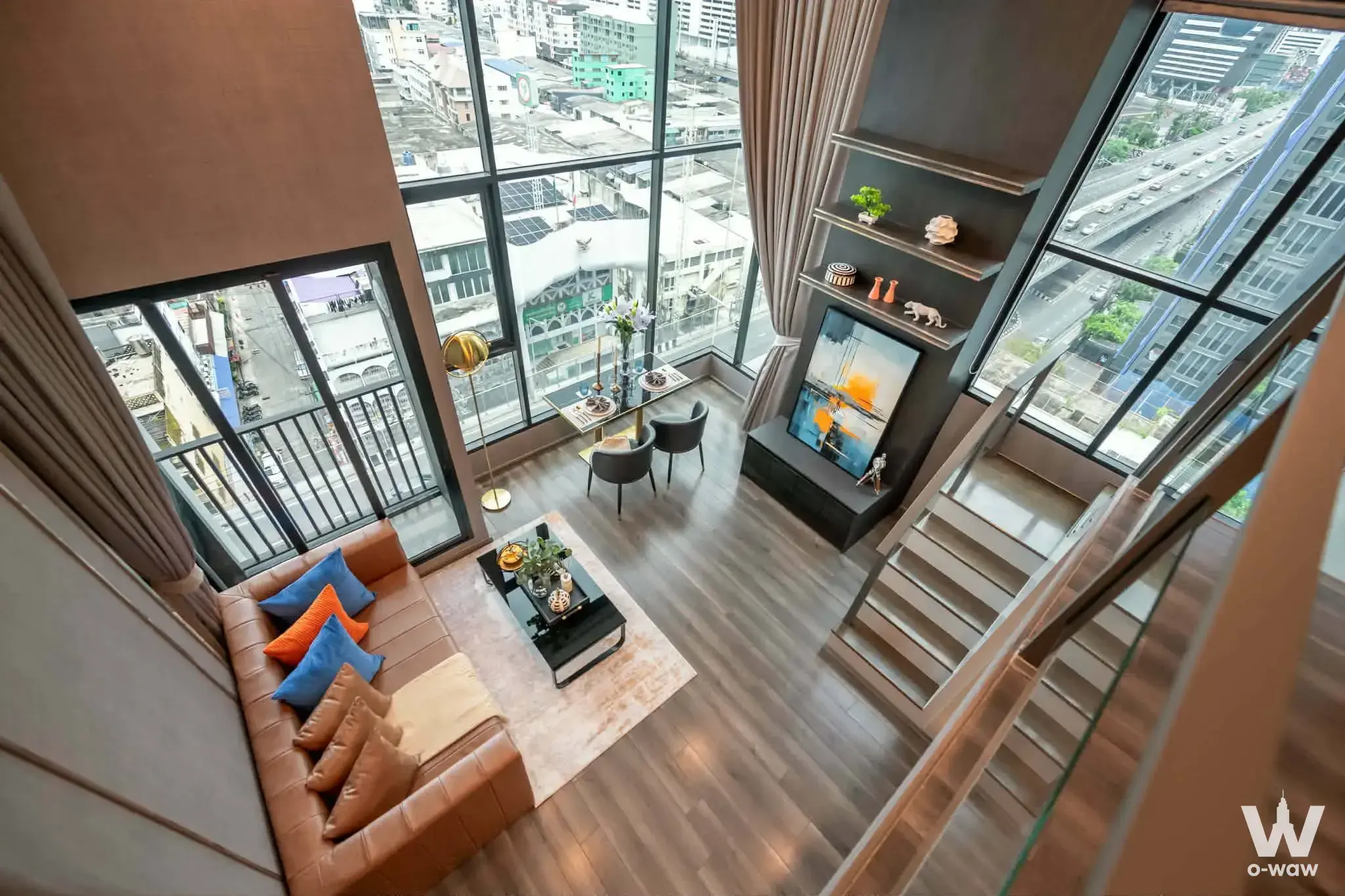 Duplex living room in KnightsBridge Space Rama 9 condo with leather sofa and city views