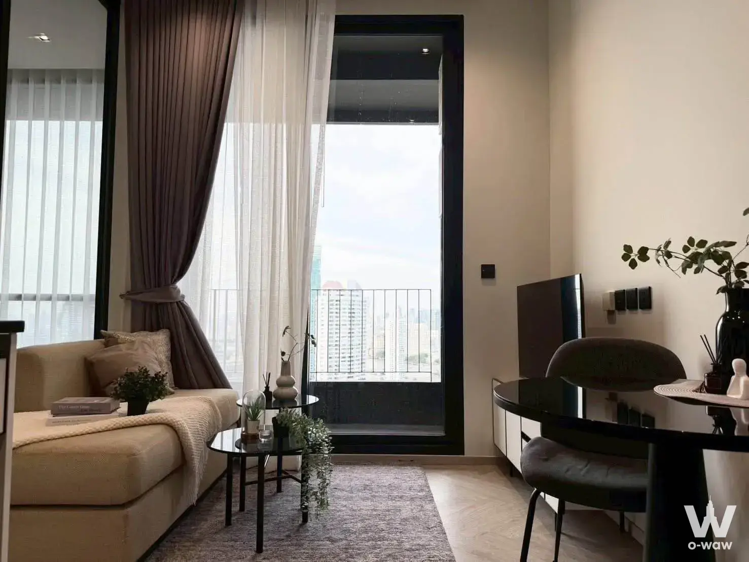 Chapter Charoennakhon-Riverside 1-bed condo living room with sectional sofa, herringbone floor, and skyline view