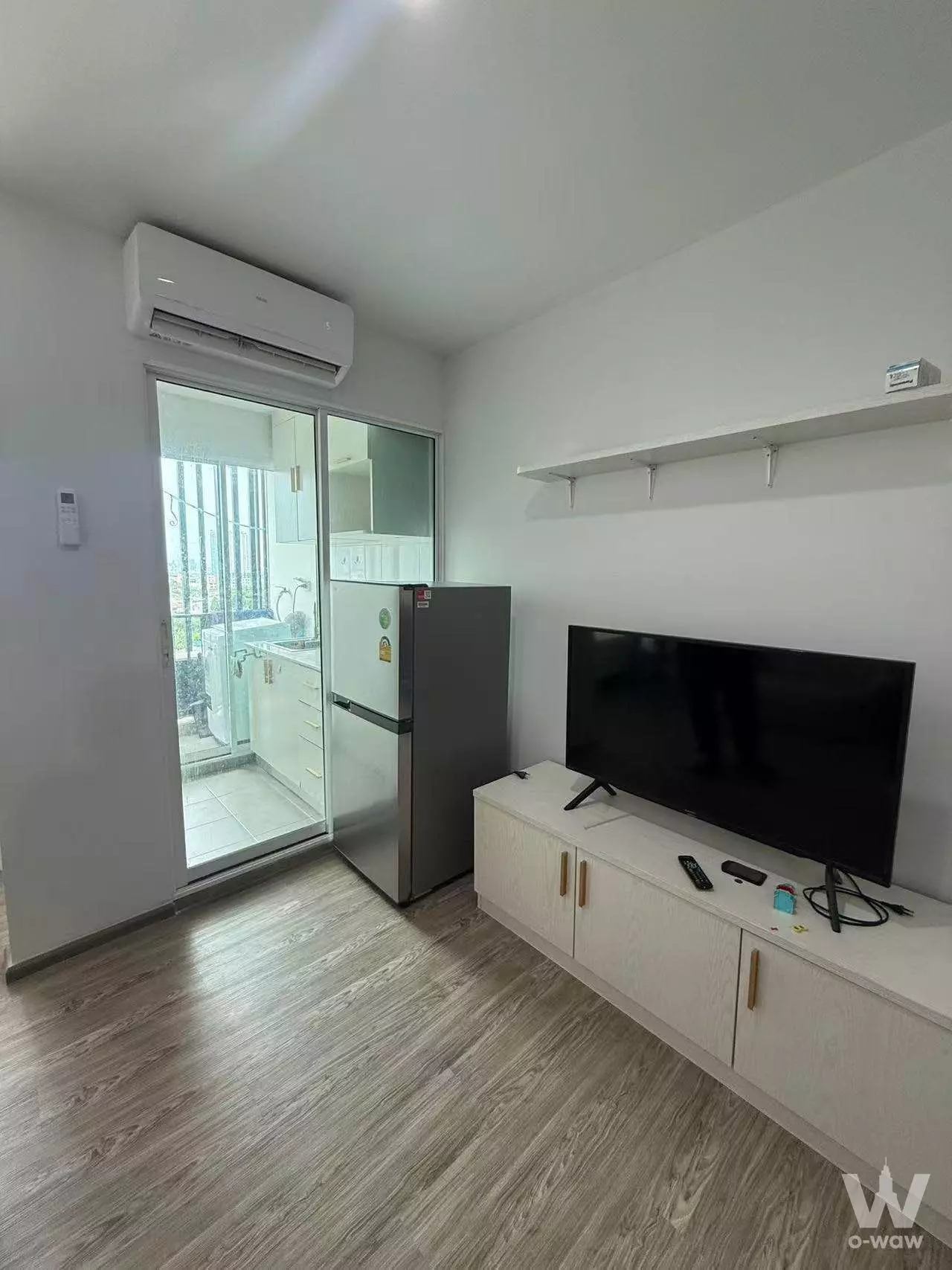 Bright 1-bed condo living area in Regent Home Bangson 28 with wood-look floors, TV console, and balcony access