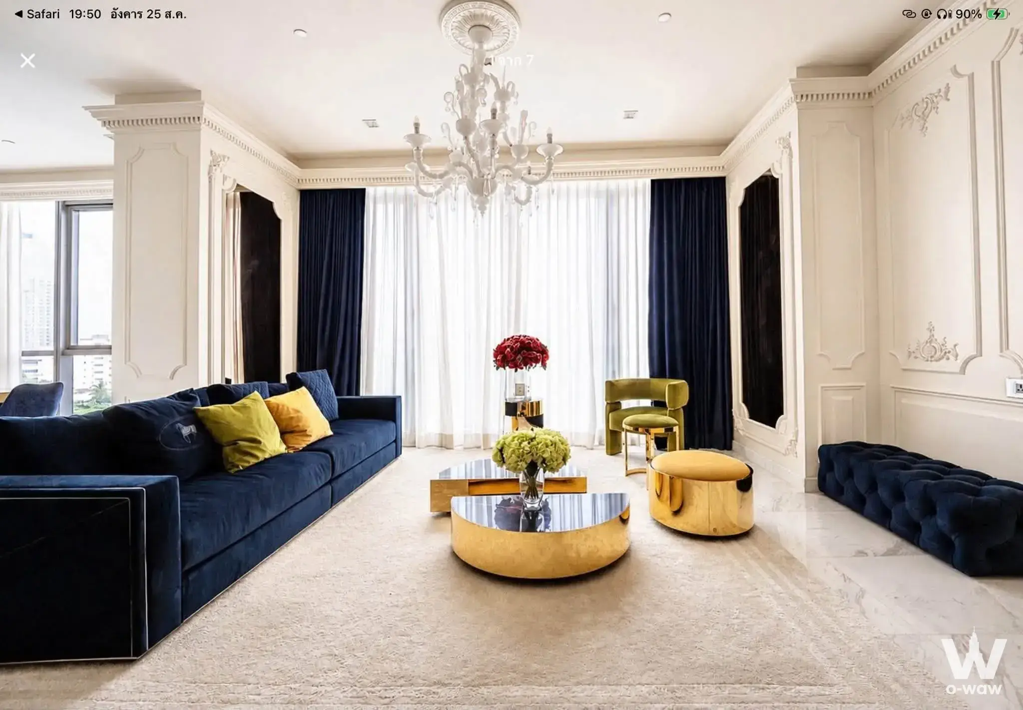Luxury living room in The Monument Thong Lo with navy velvet sofa, crystal chandelier, and floor-to-ceiling windows