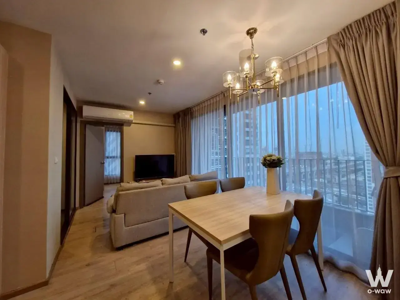 Furnished dining area in this Ideo O2 2-bed rental with a brass chandelier and floor-to-ceiling city views