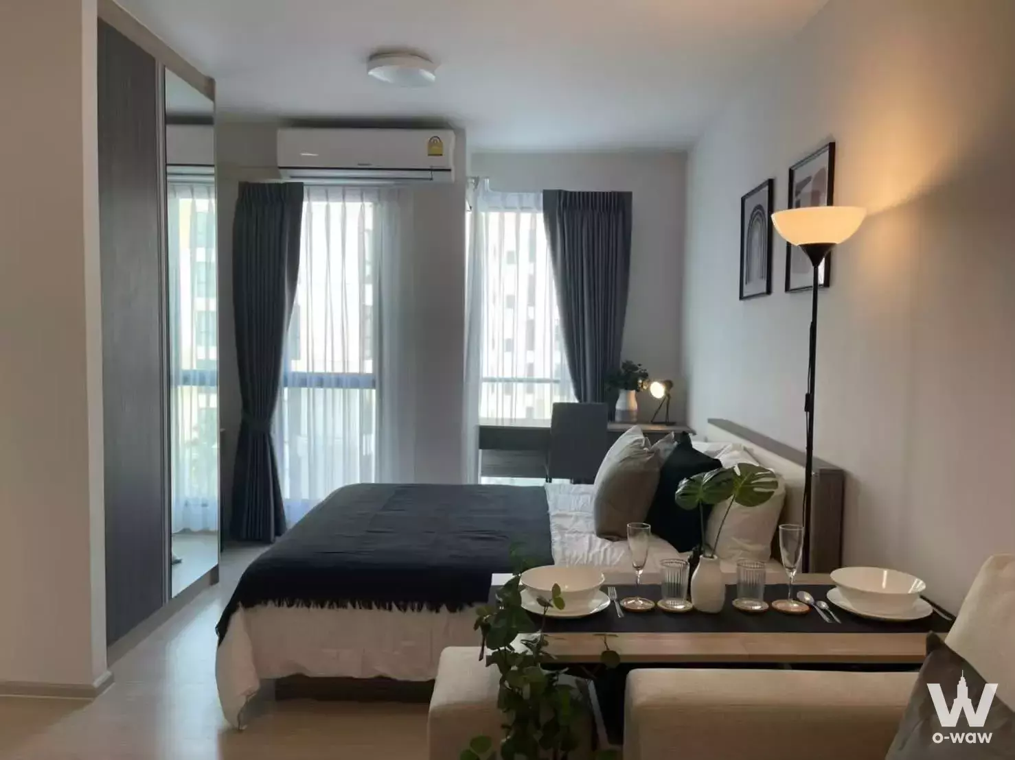 Bedroom in UNiO Sukhumvit 72 condo with double bed, wardrobe, and city view
