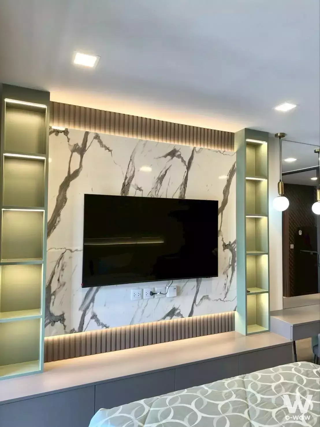 Bedroom in Life Phahon-Ladprao unit with marble TV wall, sage green shelves, and LED lighting accents