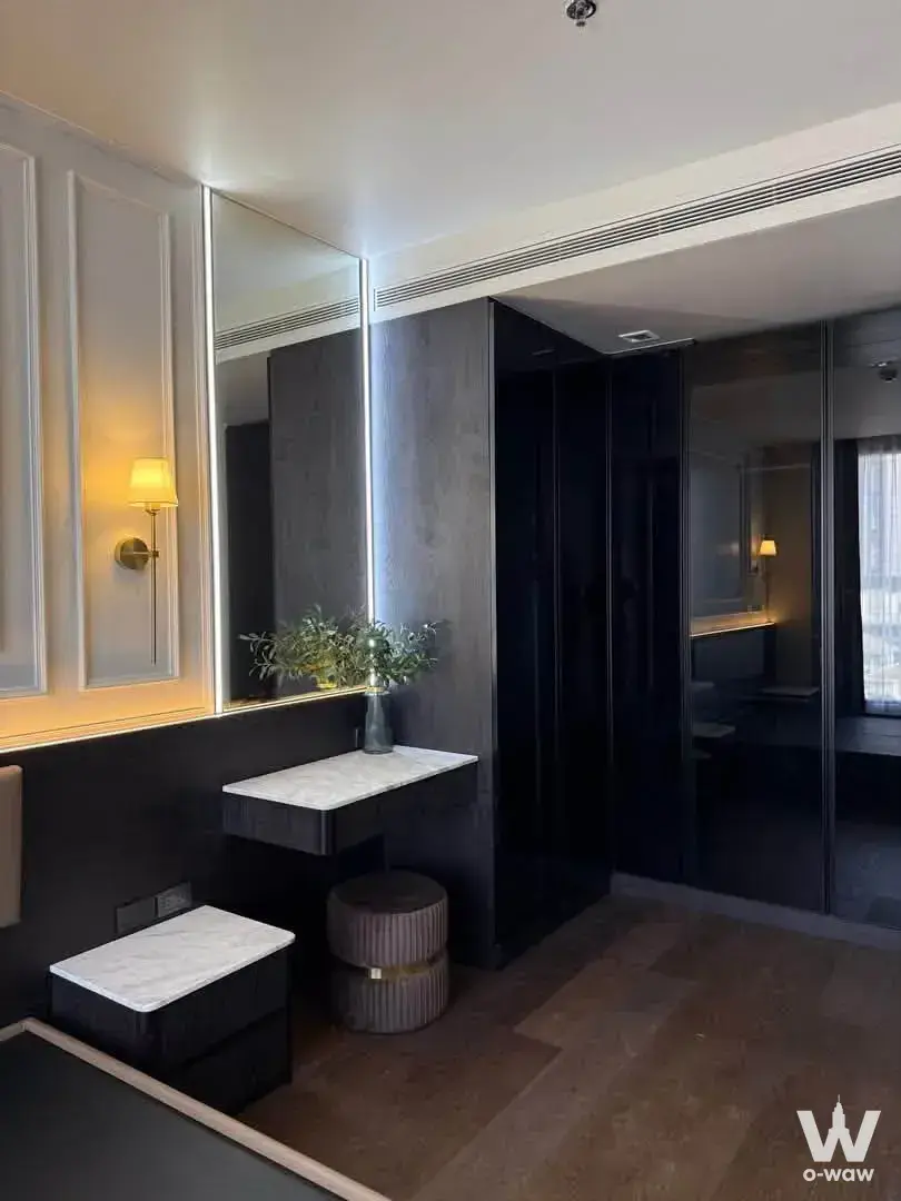 Modern bedroom in The Saint Residences condo with charcoal walls, marble vanity, and gold accents