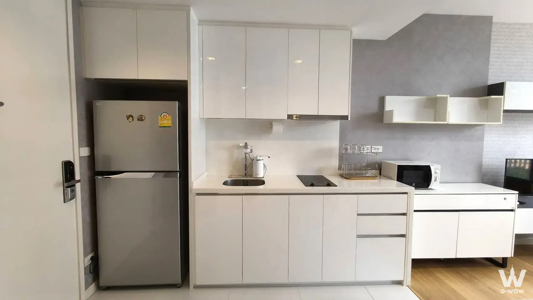 Modern kitchen area in 1-bed condo for sale at Nara 9 by Eastern Star with white cabinetry