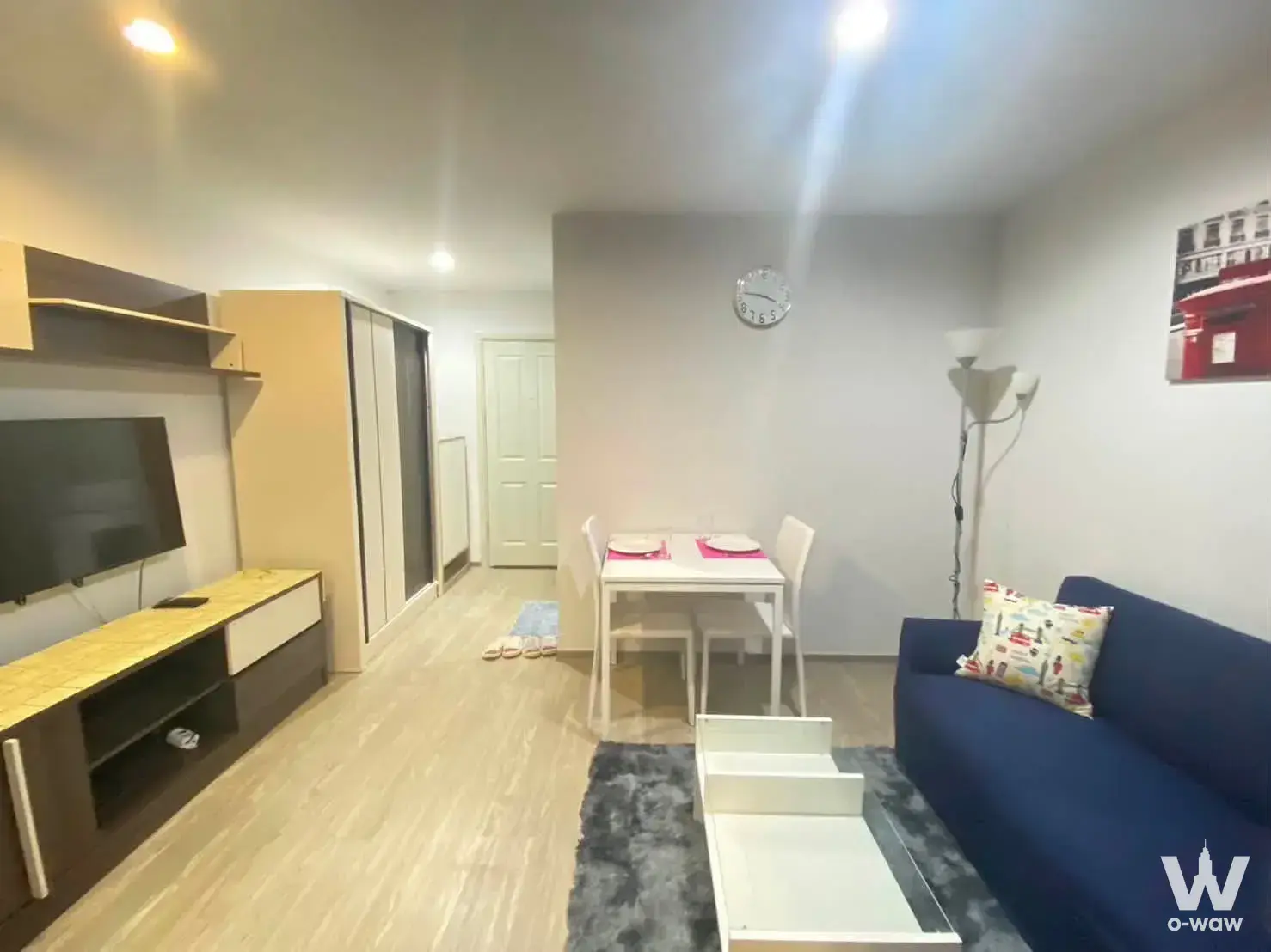 Compact living and dining space with navy sofa and wood console in this 0-bed house for rent at Regent Home 97/1