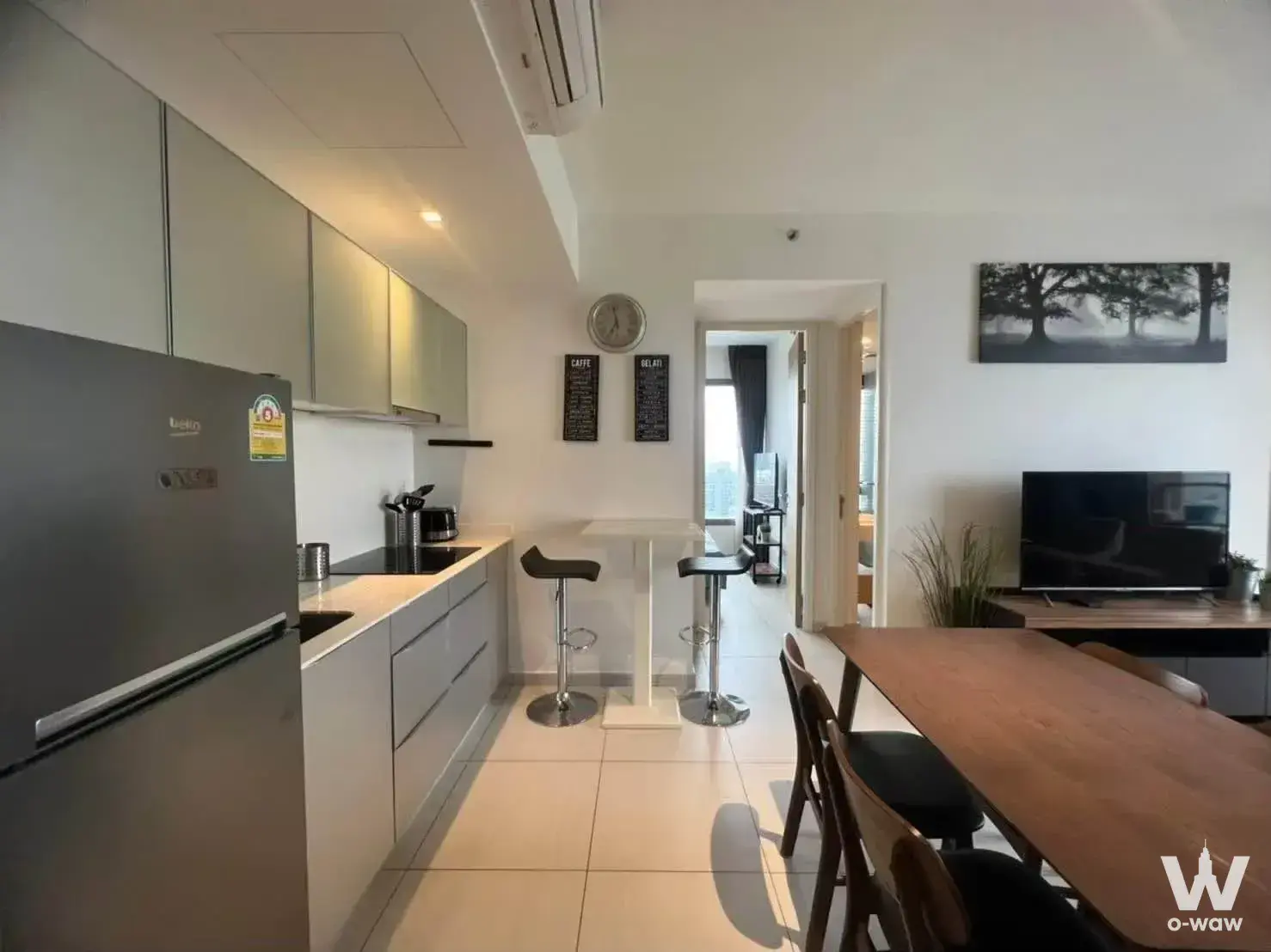Open-plan kitchen and dining area in a 2-bed condo for rent at The Lofts Ekkamai with modern grey cabinetry