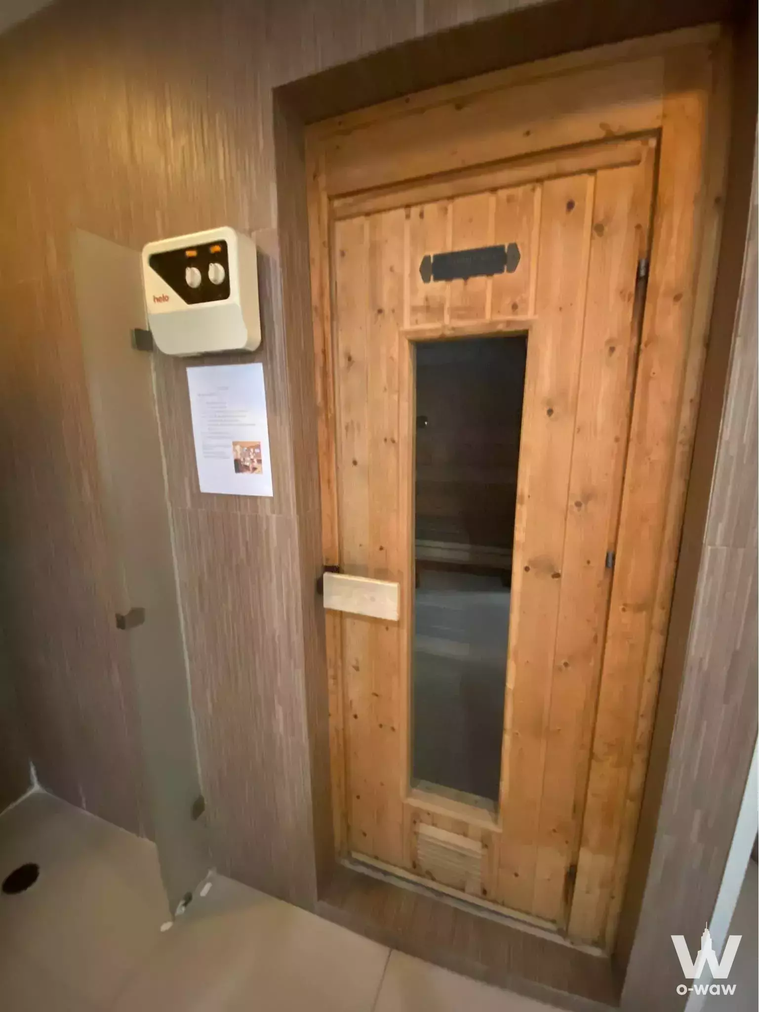 Wood-paneled sauna room with glass door and intercom unit in amenity area of 1-bed condo for rent at ADDERA CONDO CHAENG