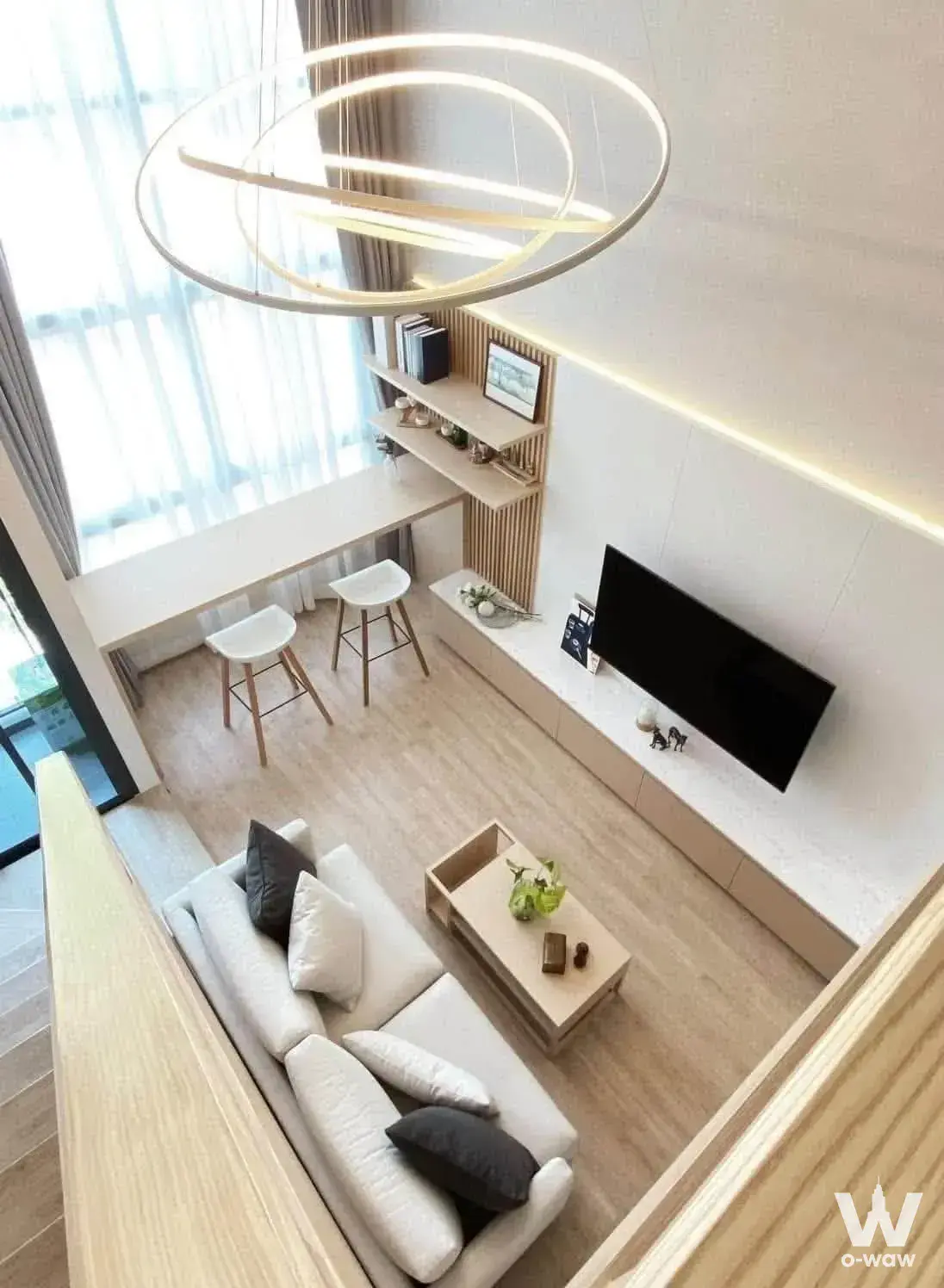 Scandinavian living room with wood slat accent wall and ring chandelier in Ideo New Rama 9