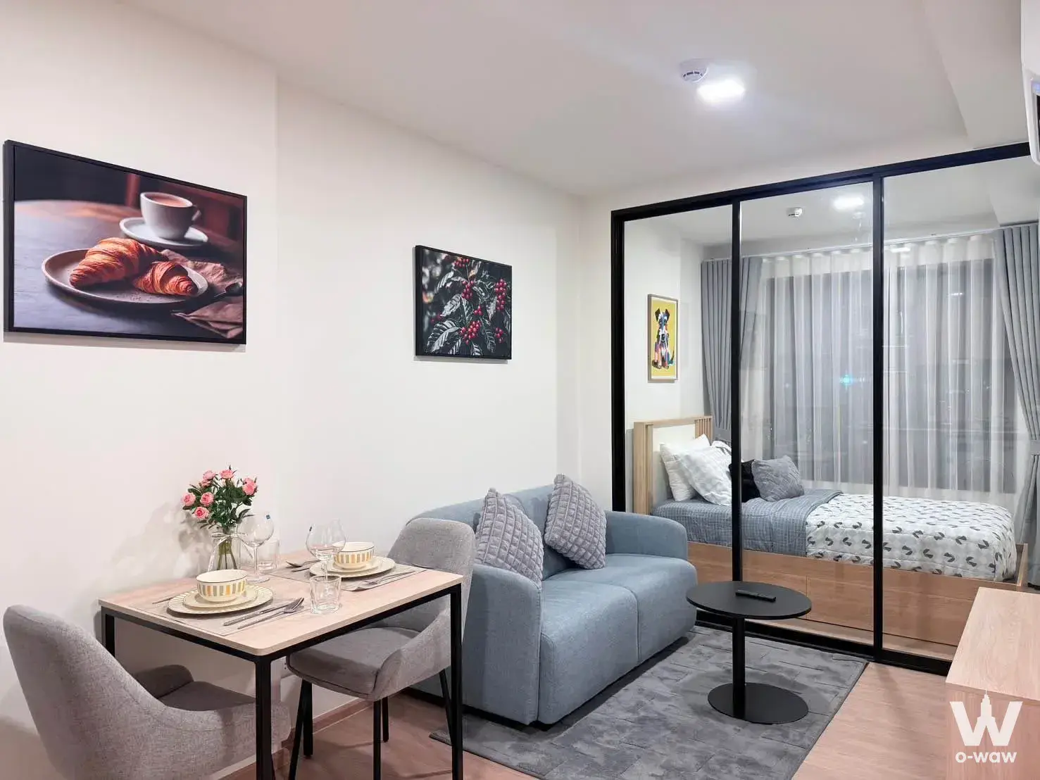 Studio apartment in The Base Bukit Phuket with open plan layout, wooden platform bed, and artwork