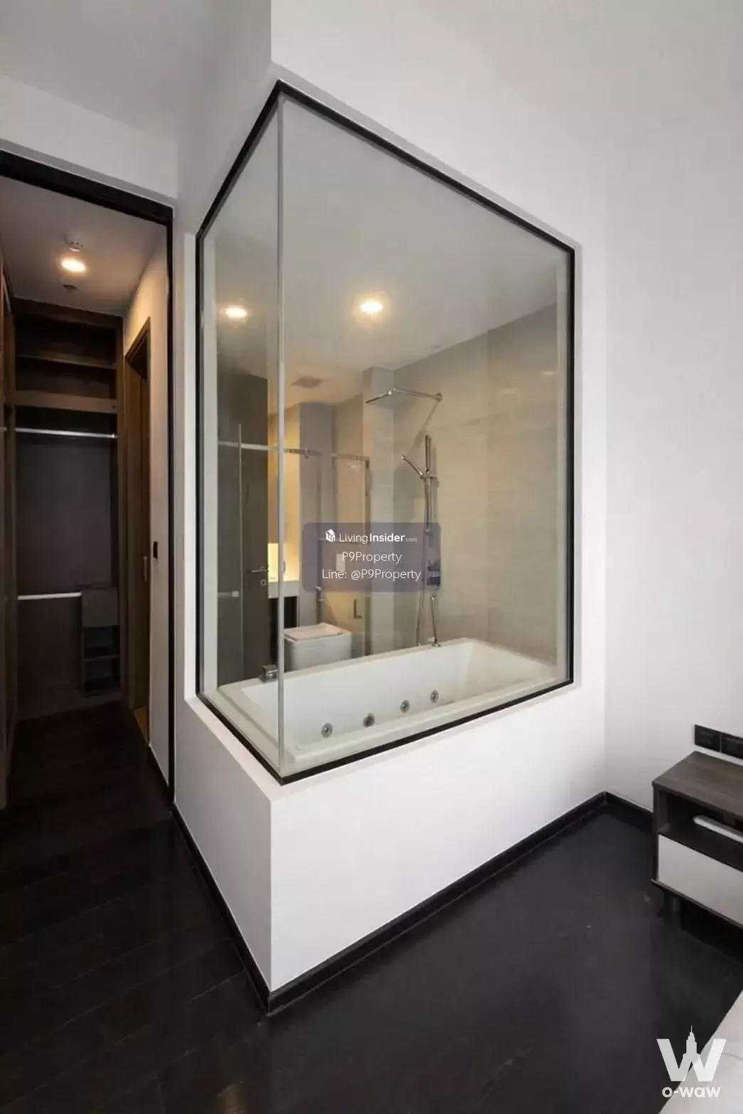 Bedroom suite with dark wood floors and glass-enclosed jacuzzi bathroom in Park Origin Thonglor