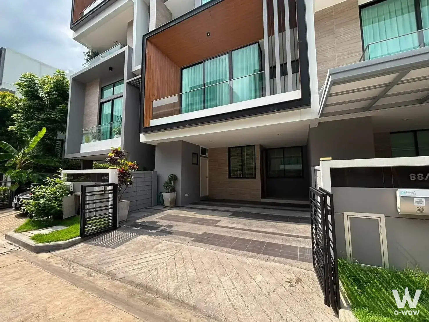 Modern 3-bed Nirvana Define Rama 9 townhouse exterior with grey stucco facade, wood accents, and glass balcony
