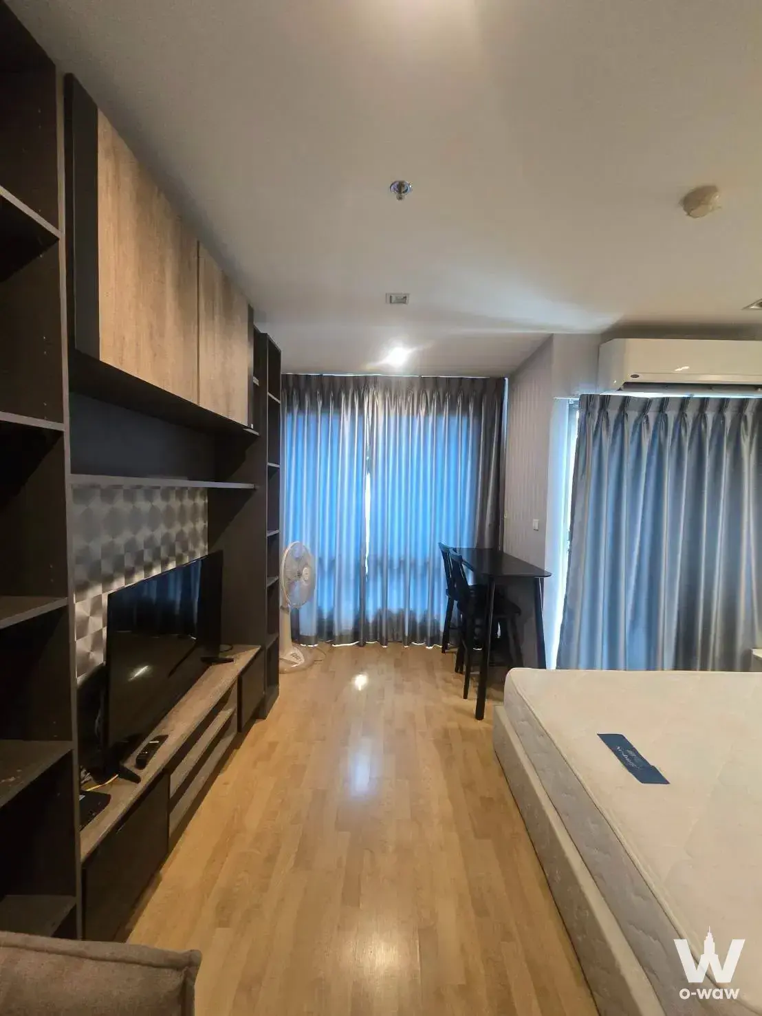 Studio layout featuring built-in media wall, queen bed, and dining set in Casa Condo Asoke-Dindaeng 1-bed rental