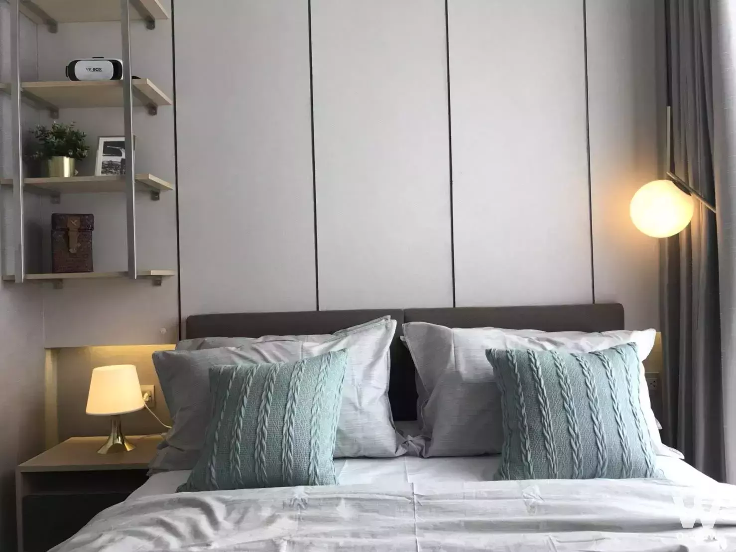 Queen bed with teal pillows in 1-bed condo for sale at NUE Noble Ratchada Lat Phrao
