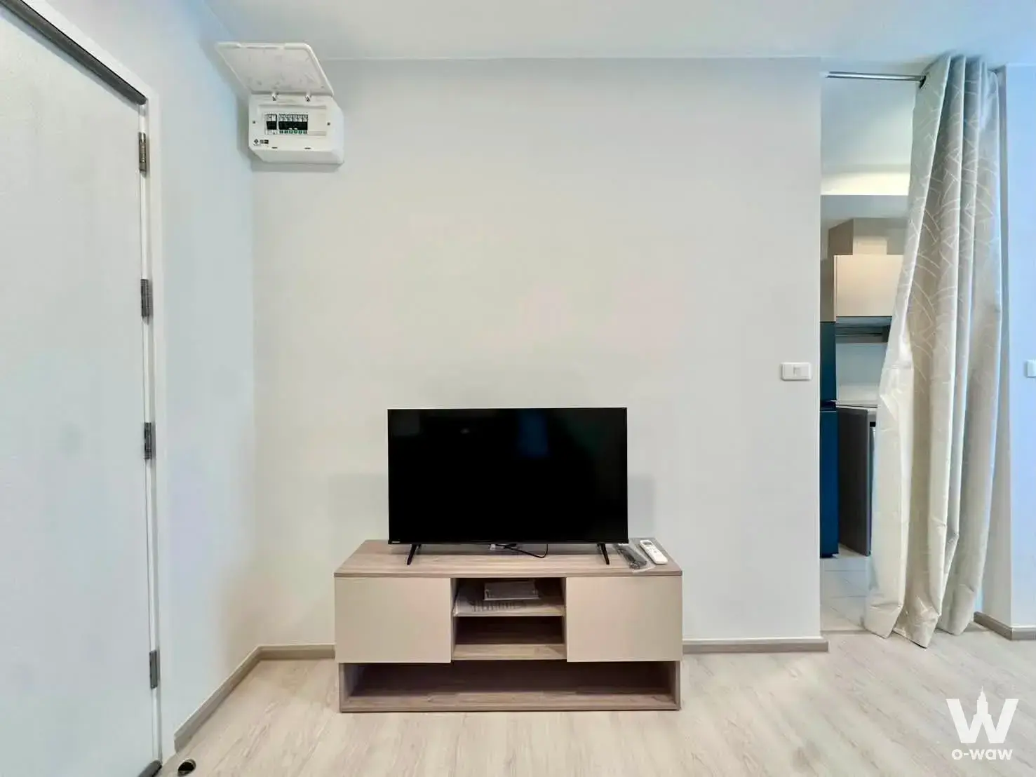 Living room with a light wood media console and flat-screen TV in a Plum Condo Sukhumvit 62 rental