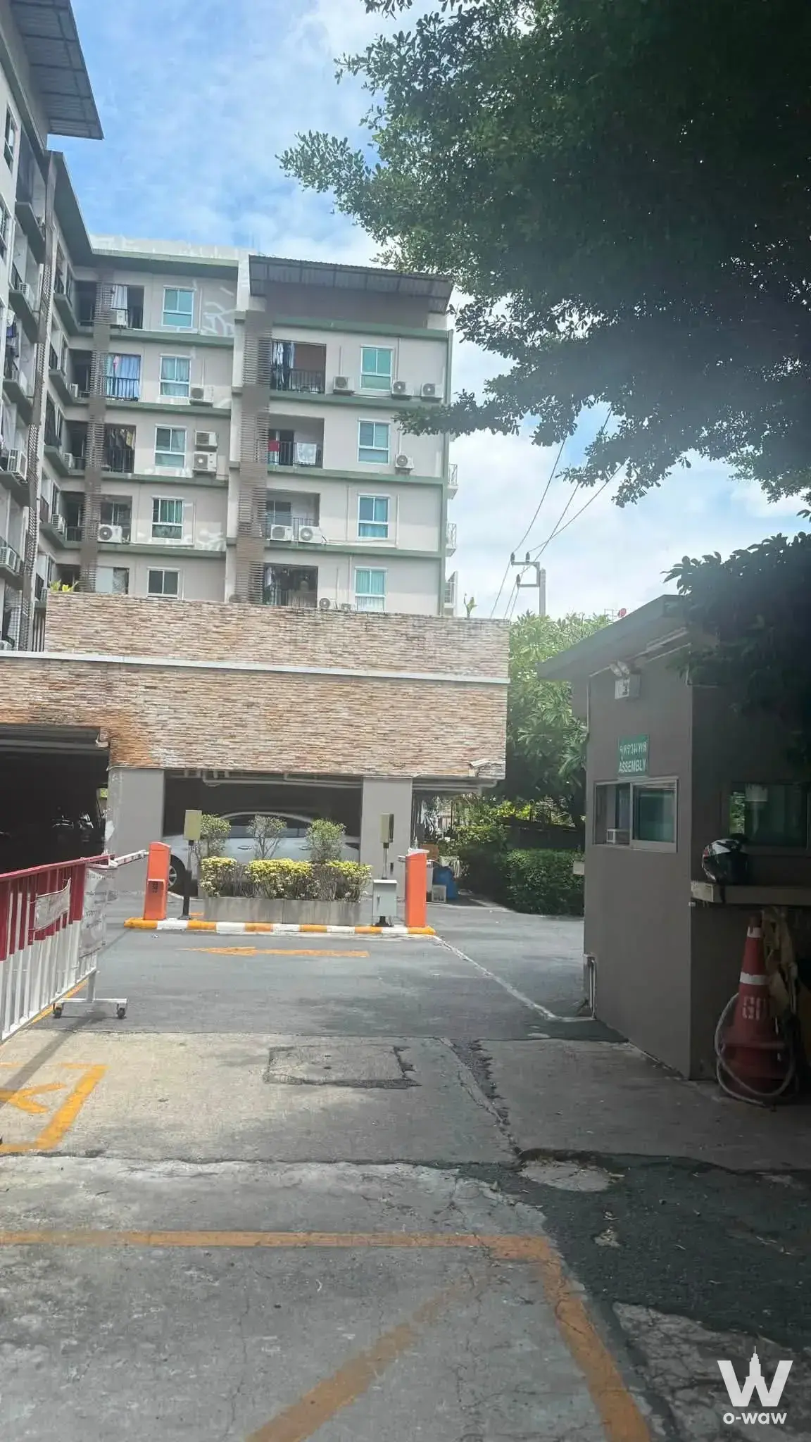 Entrance to the 6-story Regent Home 4 complex featuring beige facade, barrier gate, and guard booth