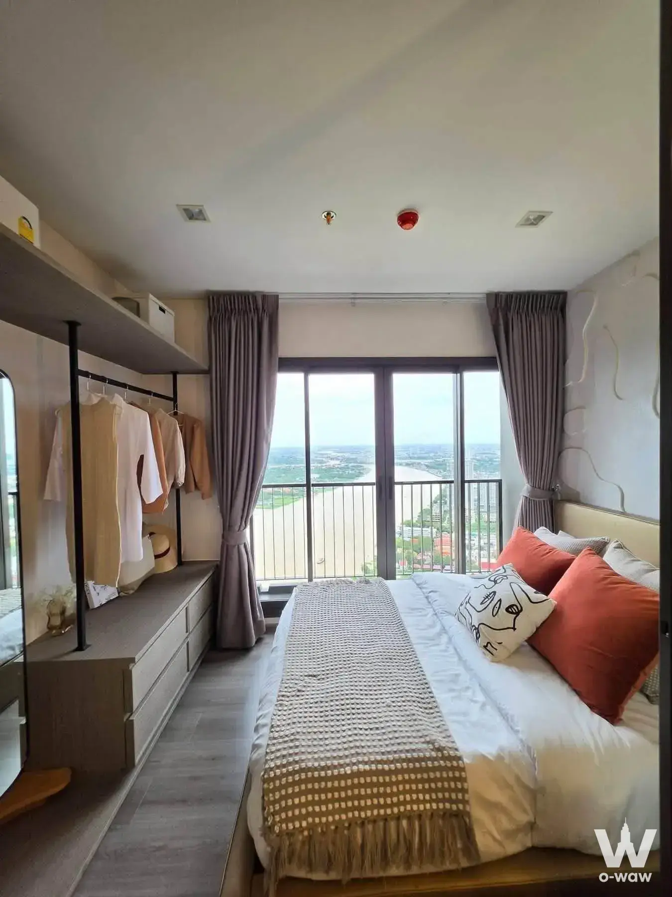 Master bedroom in a 1-bed Politan Aqua condo with a queen bed, terracotta pillows and a high-floor river view