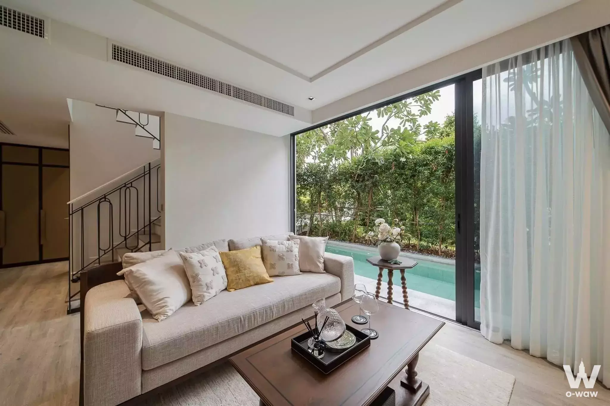 Living room with beige sofa and pool view in InterContinental Residences Hua Hin