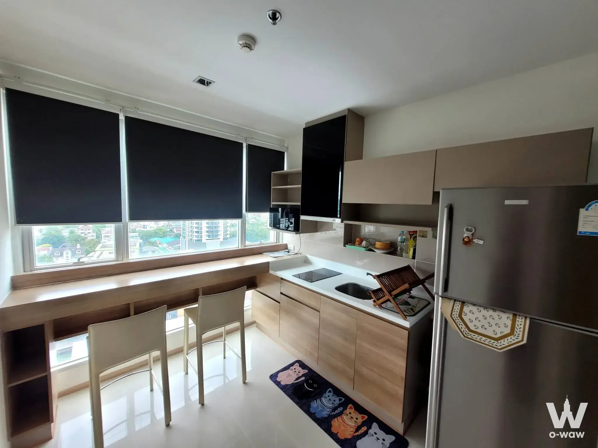 Functional kitchen dining area with light wood cabinetry and city view in 1-bed condo for rent in RHYTHM Phahon-Ari