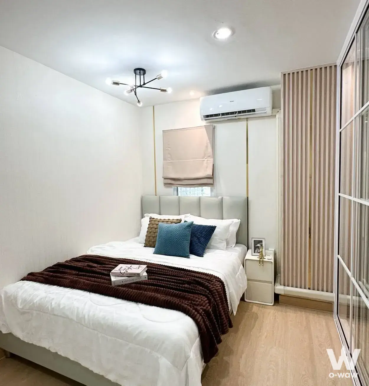 Regent Home Bangson 27 1-bed condo bedroom featuring sputnik chandelier and wood slats