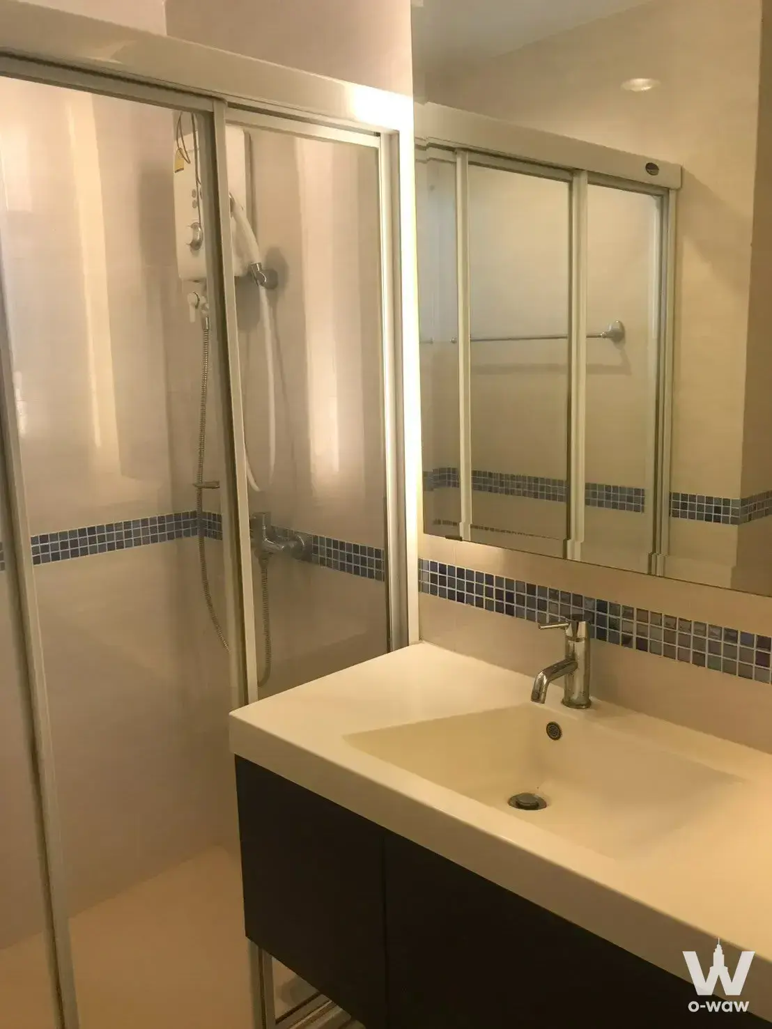 Bathroom with blue mosaic tile accents and glass shower enclosure in Life @ Sukhumvit 65