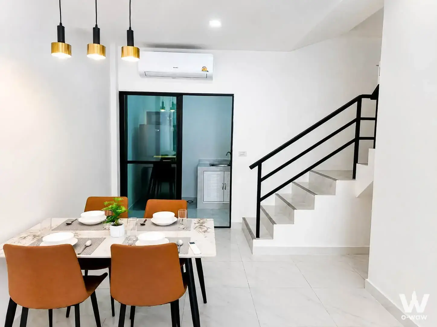 Marble dining table with tan leather chairs in a modern 3-bed house for rent at Ratnakorn Village 17