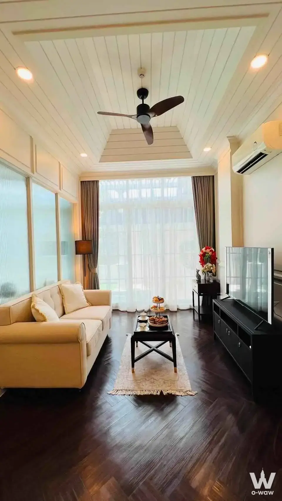 Spacious living room with dark hardwood floors and vaulted ceiling in Grand Florida Beachfront Condo