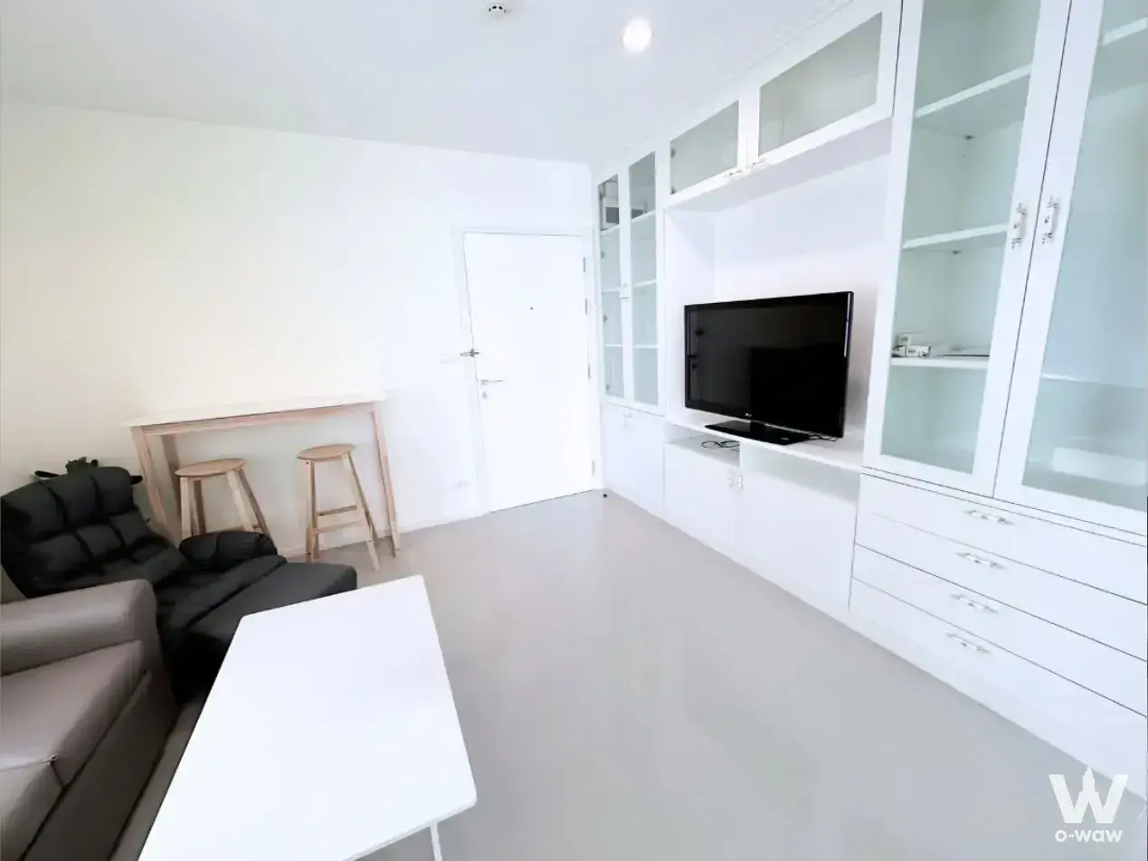 Modern 2-bed condo living room for rent in Aspire Sukhumvit 48 with white entertainment unit and neutral palette