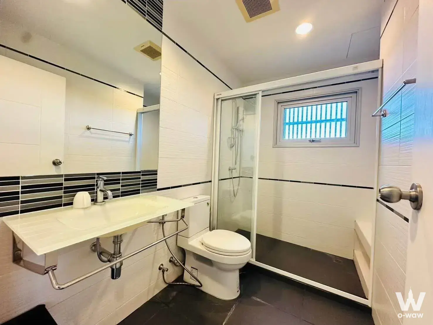Modern bathroom with white vanity, subway tiles, and glass shower in Centric Sea Pattaya 2-bed condo