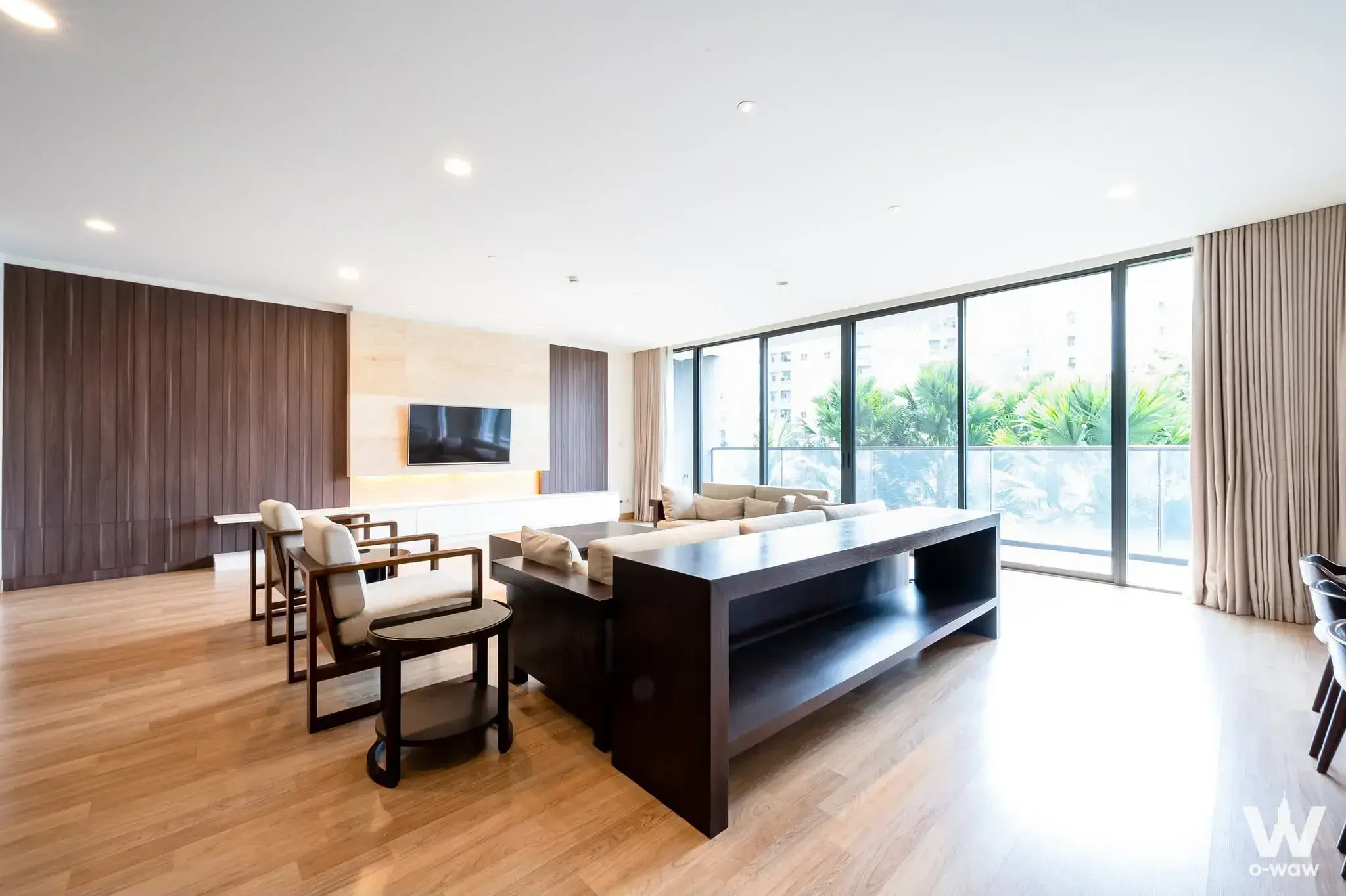 Luxury living room with walnut slat feature wall and palm tree view in Park Court Sukhumvit 77 4-bed condo