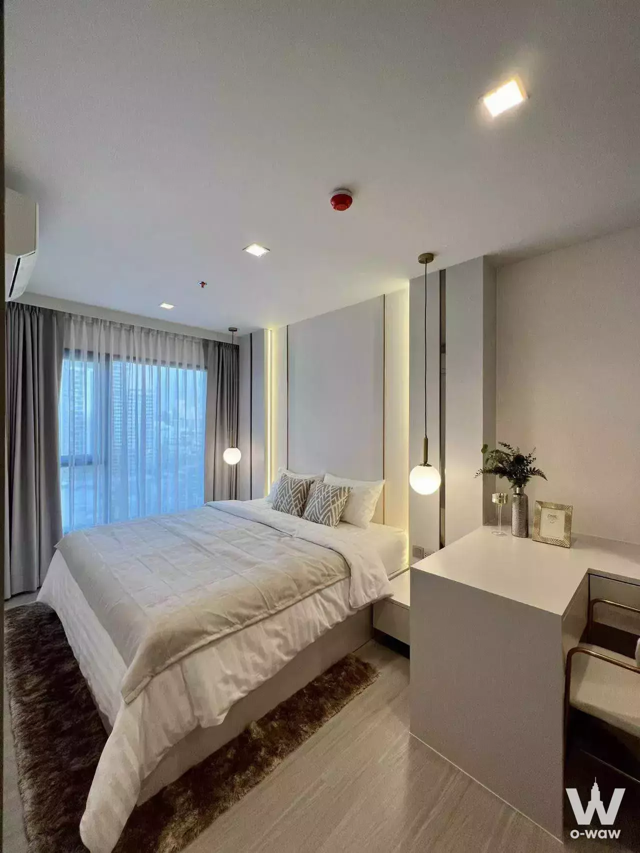 Life Asoke Rama 9 bedroom with LED paneling, spherical pendants, faux-fur rug, and city views