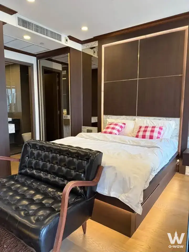 Luxury master bedroom with queen bed underglow lighting, dark wood headboard, and mirrored wall panels reflecting bathroom