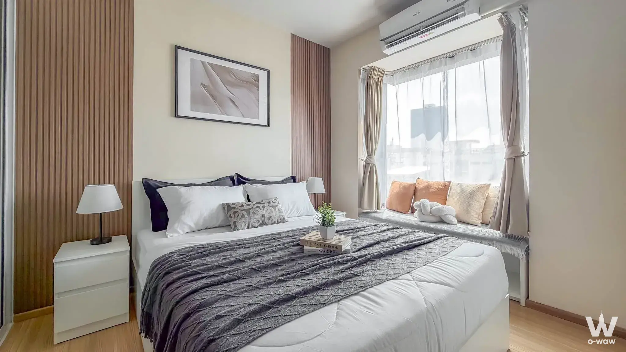 Modern bedroom in Fuse Mobius 1-bed condo with wood slat walls, queen bed, and window bench