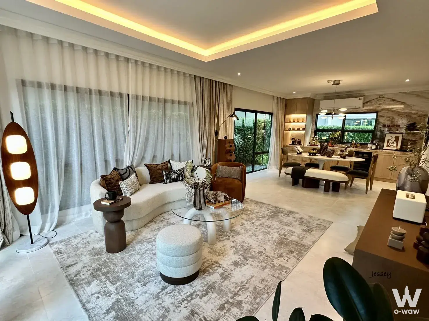 Spacious living room with marble floors, white sofa, and balcony access in 4-bed Setthasiri house