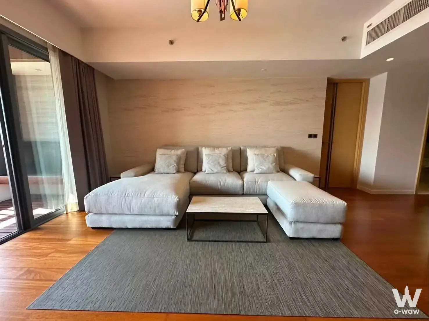 Modern 1-bed condo living room in The Pano with L-shaped sofa and marble coffee table
