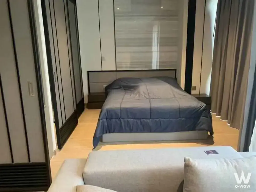 The master bedroom of this Andromeda 1-bed condo for rent has a queen bed, a built-in wardrobe and a curtained window