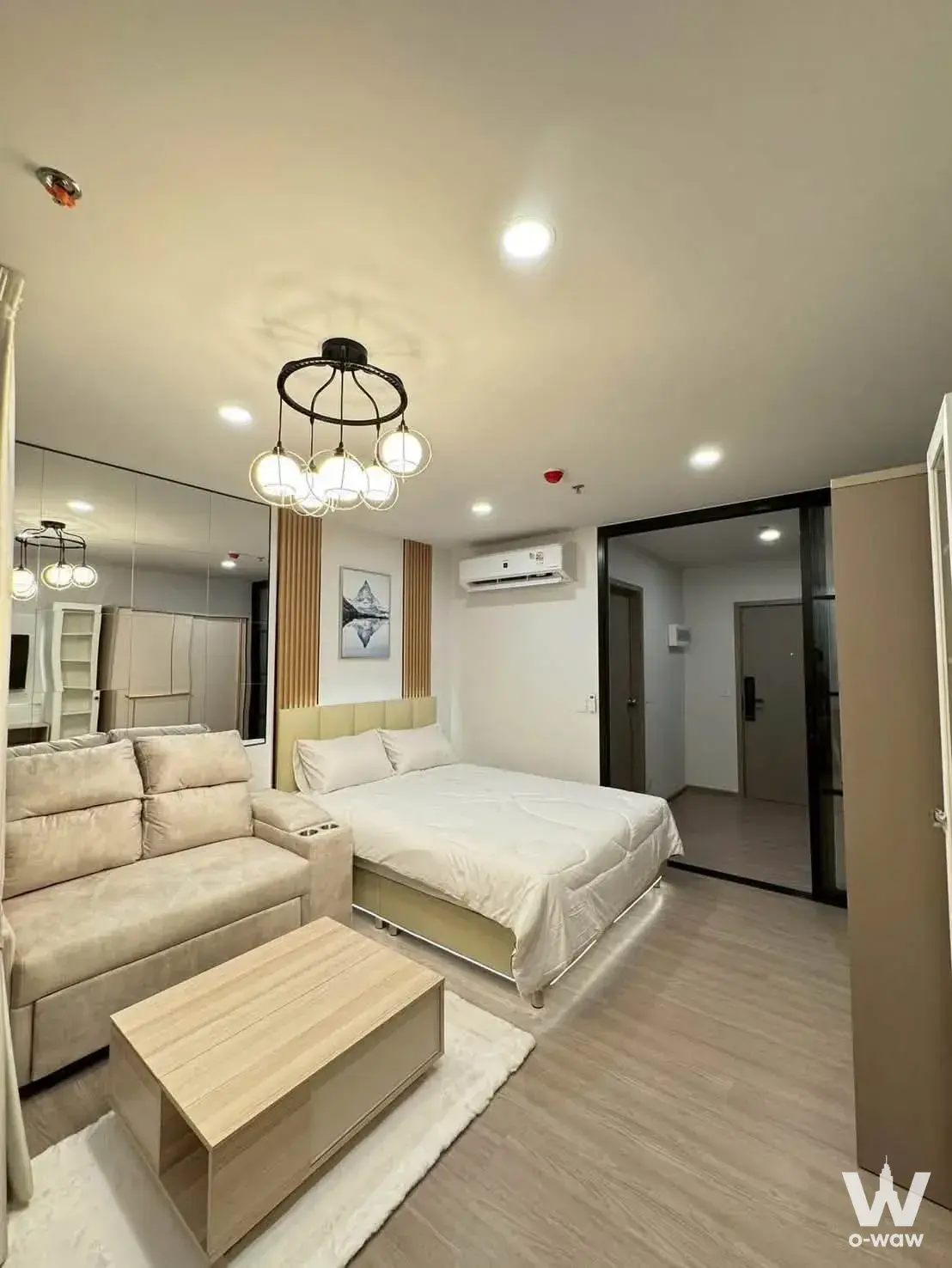 Bedroom in Aspire Sukhumvit-Rama 4 condo with queen bed, LED underglow, floor-to-ceiling mirror, and neutral decor