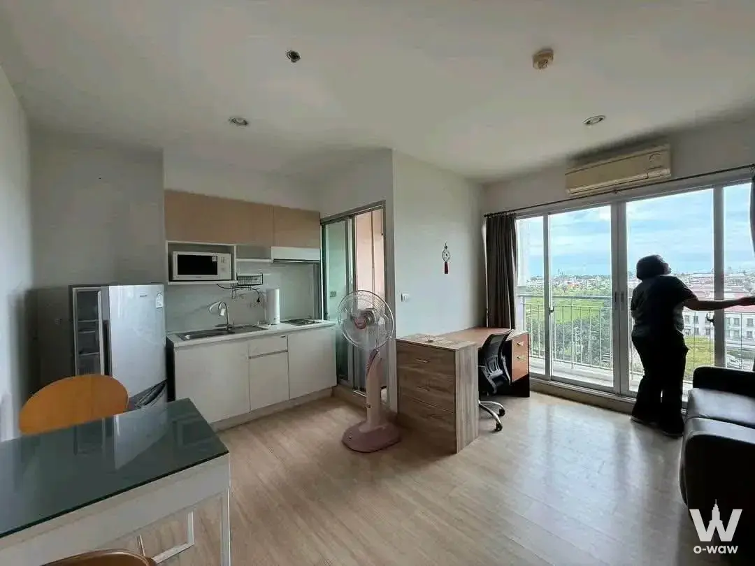 Bright 1-bed condo in The Parkland Srinakarin Lakeside featuring light wood floors and a city view through sliding glass