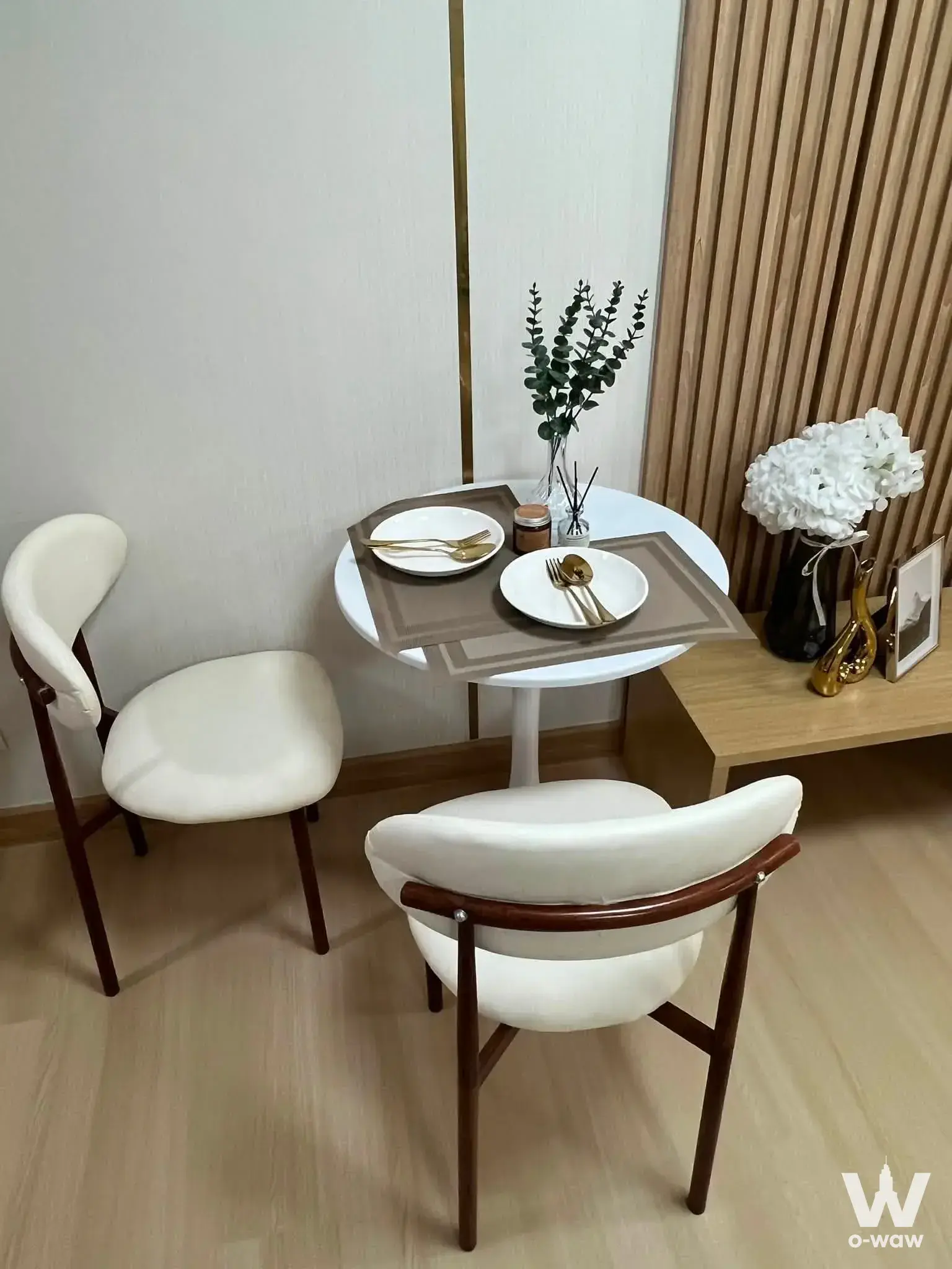 Compact dining nook in a Ratchada City 18 condo with walnut chairs and a wood slat accent wall