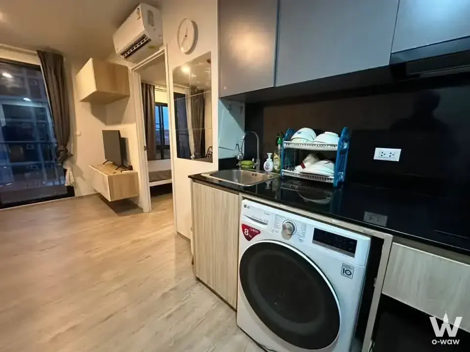 DOLCE LA SALLE 1-bed condo for sale features a compact kitchen, washing machine and night city view from the balcony