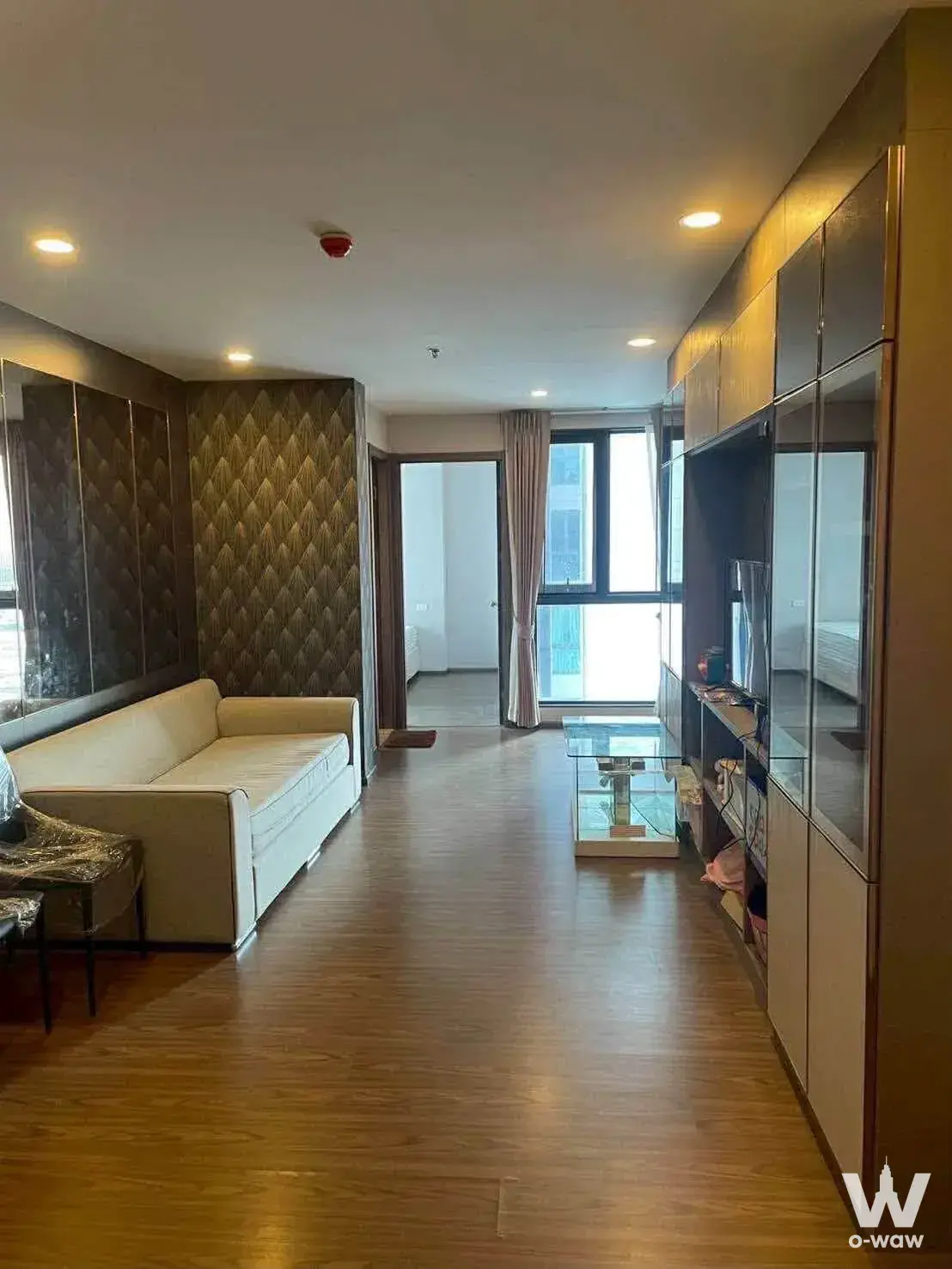 Living room in an Artisan Ratchada rental with cream leather sofa and built-in cabinetry
