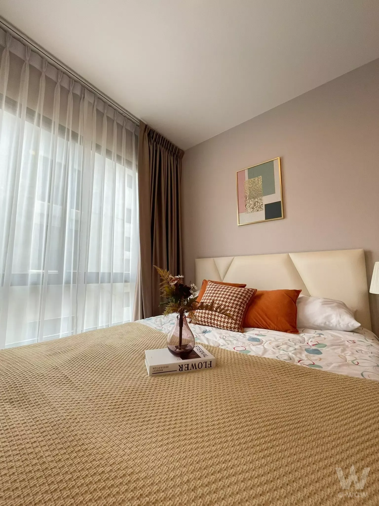 Bright bedroom with floor-to-ceiling windows and orange accents in The Sky Sukhumvit
