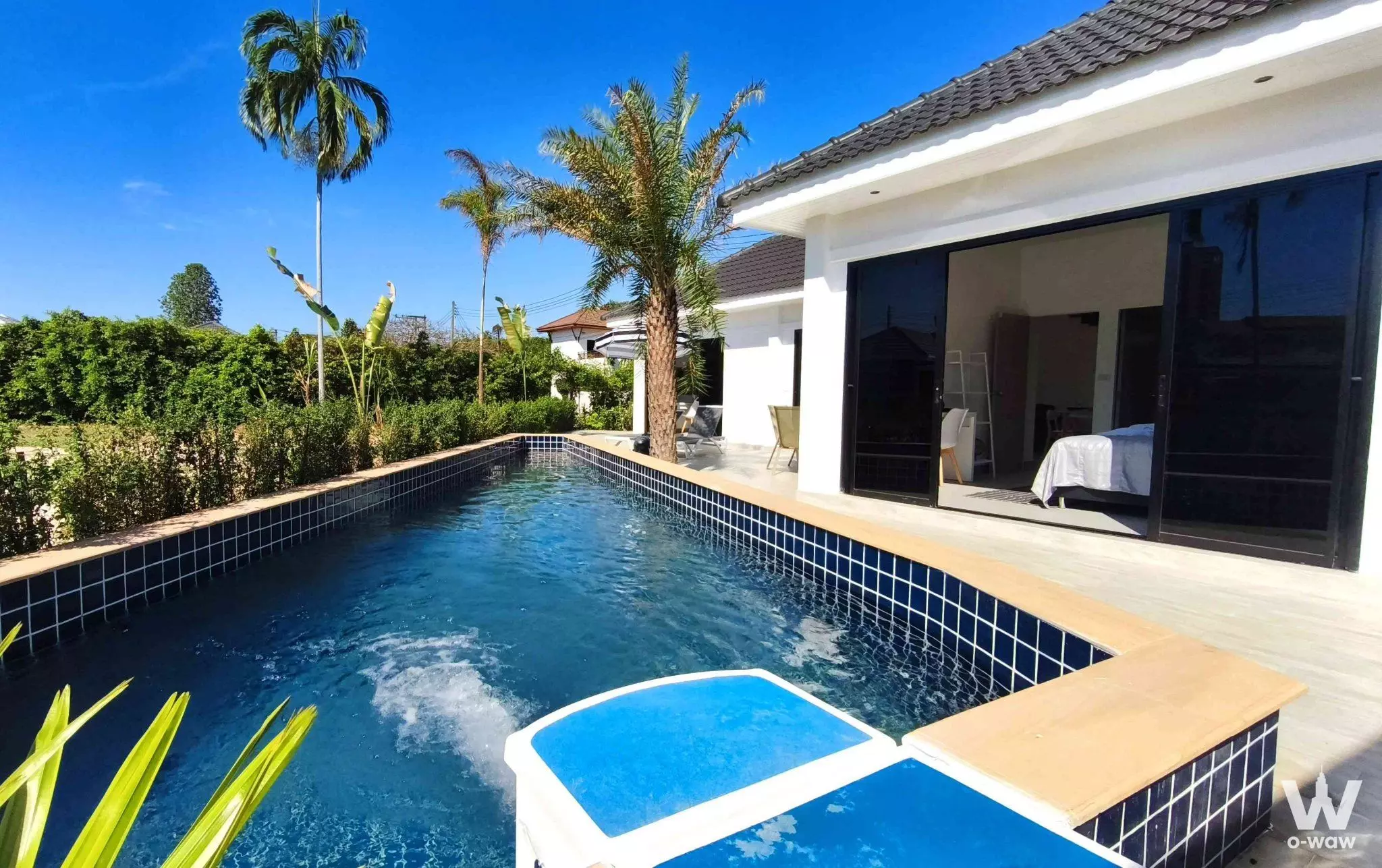 Tropical villa exterior with private pool, white spa, wooden deck, and lush greenery in VIP Chain Resort