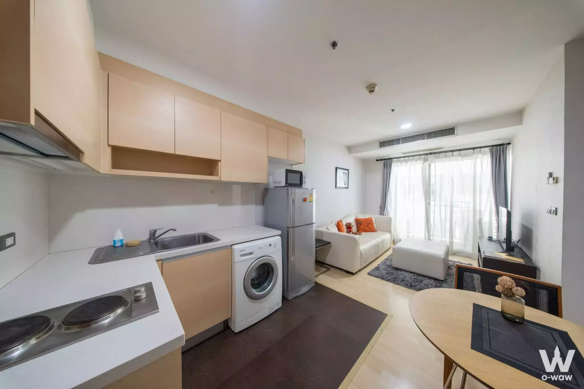 Open-plan kitchen and living area in 59 Heritage townhouse with maple cabinets and large windows