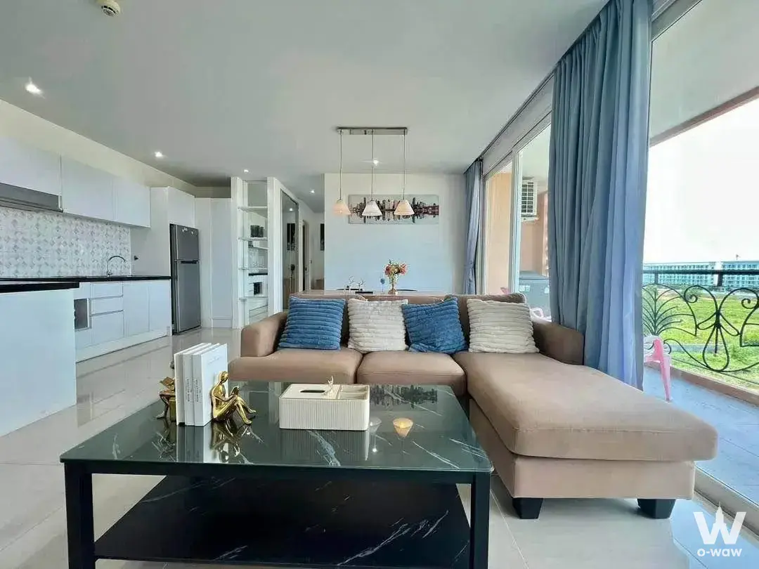 Beige sectional sofa and open kitchen in a bright Atlantis Condo Resort Pattaya living room