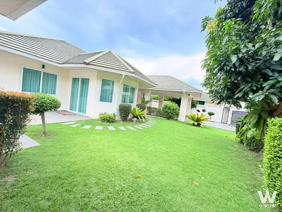 Exterior of Siam Country Club Bangkok 2-bed condo with manicured lawn, stone path, and cream facade