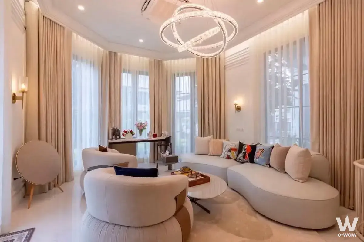 Luxurious living room in a 4-bed house for sale in Narasiri Bangna featuring a curved cream sectional sofa and crystal