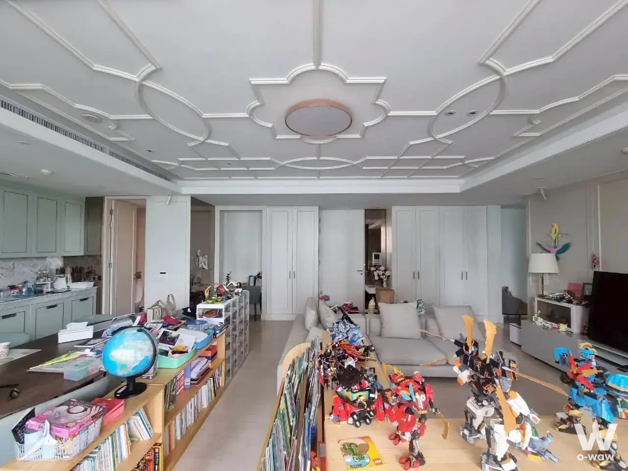 Saladaeng Residences living room with ornate ceiling molding and grey sectional sofa