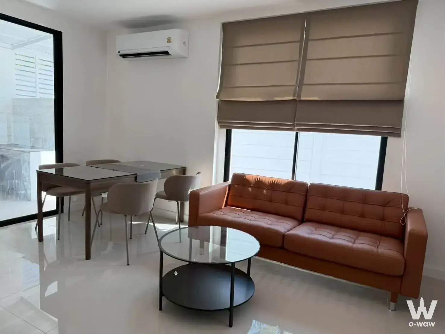 Living room with caramel leather sofa and dining set in 3-bed townhouse for rent at Areeya Mandarina